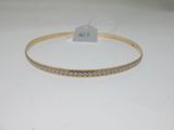 a gold bracelet with white diamonds on a white background