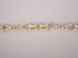 a close up of a gold bracelet on a white surface
