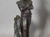 bronze statue of a man with a hat on his head holding a dog