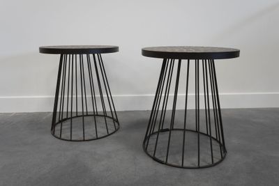 une paire de tables d'appoint noires en fil métallique avec des plateaux en marbre