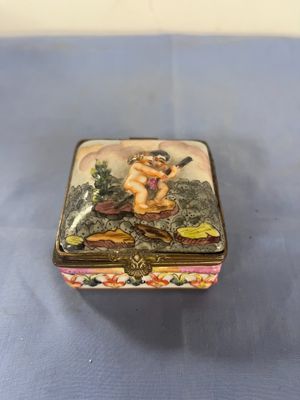 a small box with a painting on it on a blue surface