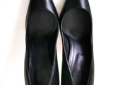 pair of black leather shoes on a white surface with a white background