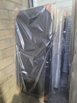 a pile of furniture wrapped up in plastic on the floor