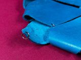 a blue purse that is sitting on a pink surface