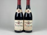 two bottles of red wine sitting next to each other on a table