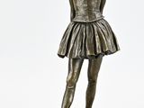 statue en bronze représentant une jeune fille en jupe, posée sur un socle en marbre