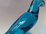 un oiseau en verre bleu posé sur une table