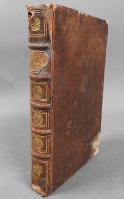 an old book sitting on top of a table next to a gray background