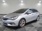 a silver car is parked on a checkered floor in a garage