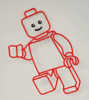 un bonhomme Lego réalisé en fil de fer rouge sur une surface blanche