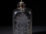 an old glass bottle sitting on top of a black table