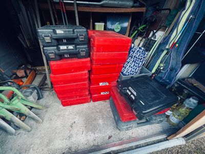 many red boxes stacked on top of each other in a garage