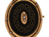 une image représentant une broche en or et noir sertie de diamants
