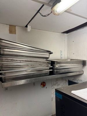 une pile de casseroles posée sur une étagère dans une cuisine