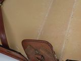 a close up of a brown leather bag on a white surface