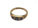 Gros plan sur une bague en or ornée de pierres bleues