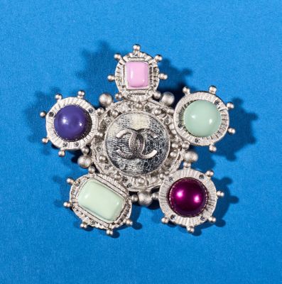an image of a brooch with a picture of a woman surrounded by gems