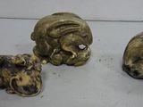 three antique brass figurines of cats and dogs on a white surface