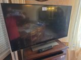 une télévision à écran plat posée sur une table en bois