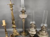 several different types of candles and candlesticks sitting on a table