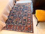 un tapis posé à même le sol, à côté d'une chaise, dans une chambre