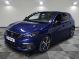 the blue car is parked on a checkered floor in a garage