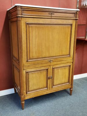 an antique wooden cabinet with marble top in a room