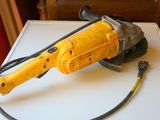 un outil électrique jaune et noir posé sur une table blanche