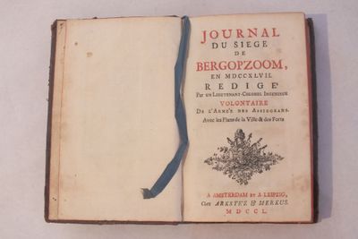 un livre orné d'un ruban bleu, posé sur une table