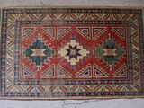 an old rug on the floor with a white wall in the background