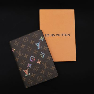 a louis vuitton passport case and a box on a black background