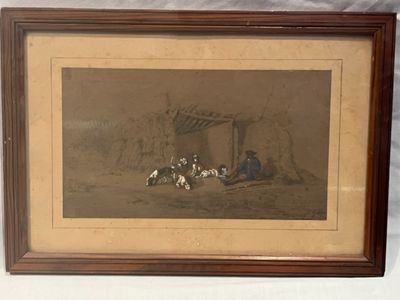 une vieille photo montrant un groupe de chiens assis devant une cabane
