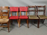 four wooden chairs are lined up against a gray backdrop