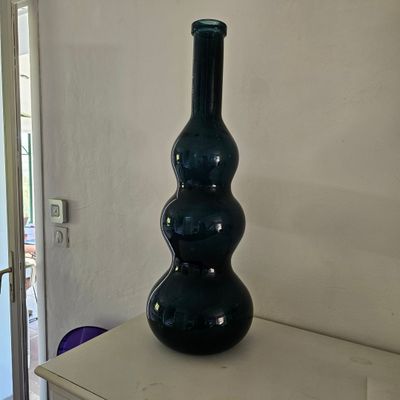 un vase noir posé sur une table blanche