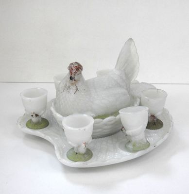 un poulet blanc posé sur un plateau avec des tasses et des soucoupes
