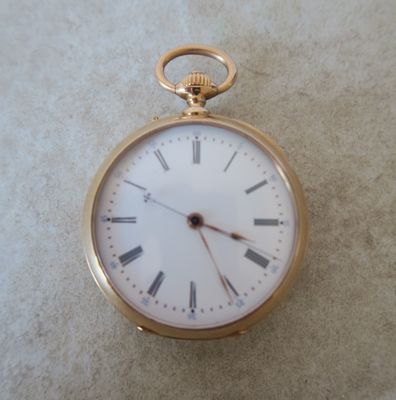 une montre de poche en or avec des chiffres romains sur le cadran