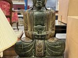 une statue de Bouddha assis sur une table