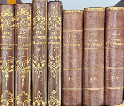 several old books are lined up on a shelf in a library