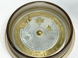 a gold and silver clock on a white surface
