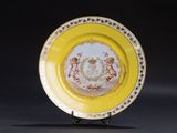 une assiette jaune ornée d'une image, posée sur un socle