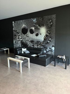 une photo en noir et blanc d'un salon avec un canapé noir