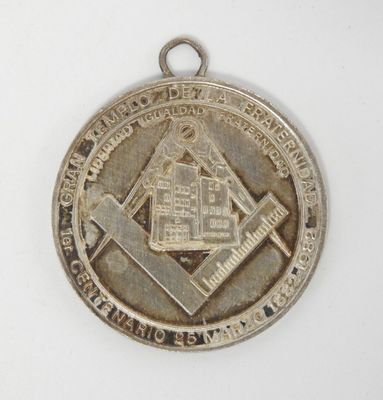 une image représentant une médaille d'argent sur laquelle figure un symbole maçonnique