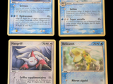 four pokemon cards are displayed on a black surface