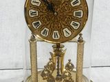 a glass dome with a gold clock inside of it