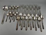 many spoons and forks laid out on the table