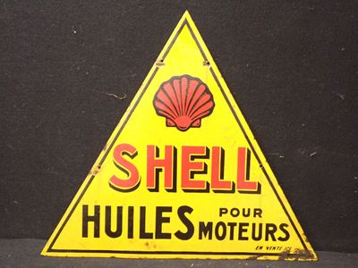 une vieille enseigne Shell « Hulles » pour l'huile moteur, posée sur un fond noir