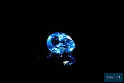 a close up of a blue diamond on a black surface
