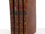 three old books sitting on top of each other on a table
