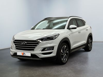 un SUV blanc garé dans une pièce au sol noir