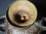 a close up of a bronze vase on a table